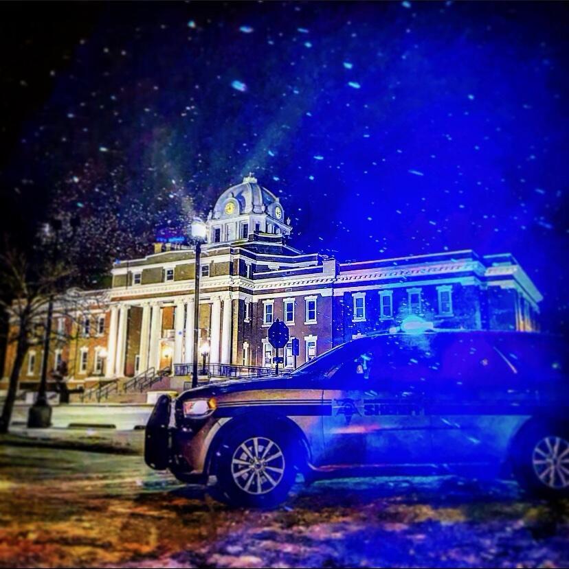 BPSO Patrol unit with lights on at night in front of the Beauregard Parish Courthouse while snowing