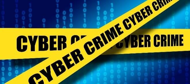 Cyber Crime on crime scene barricade tape with a screen displaying numbers in the background.